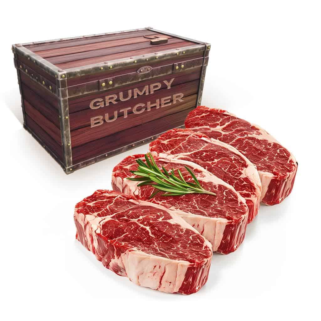 Four ribeye steaks in front of a wooden crate labeled "Grumpy Butcher".