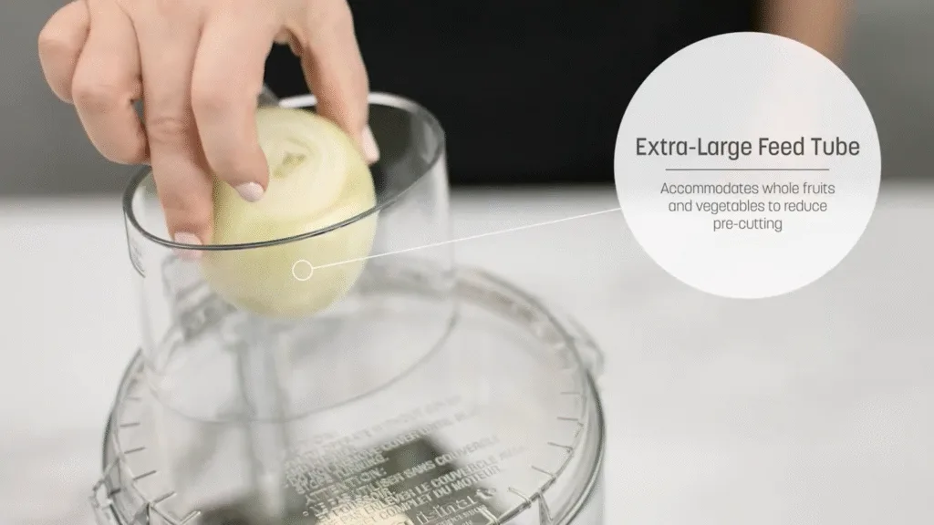 Hand placing onion in Cuisinart 14-cup food processor's extra-large feed tube.
